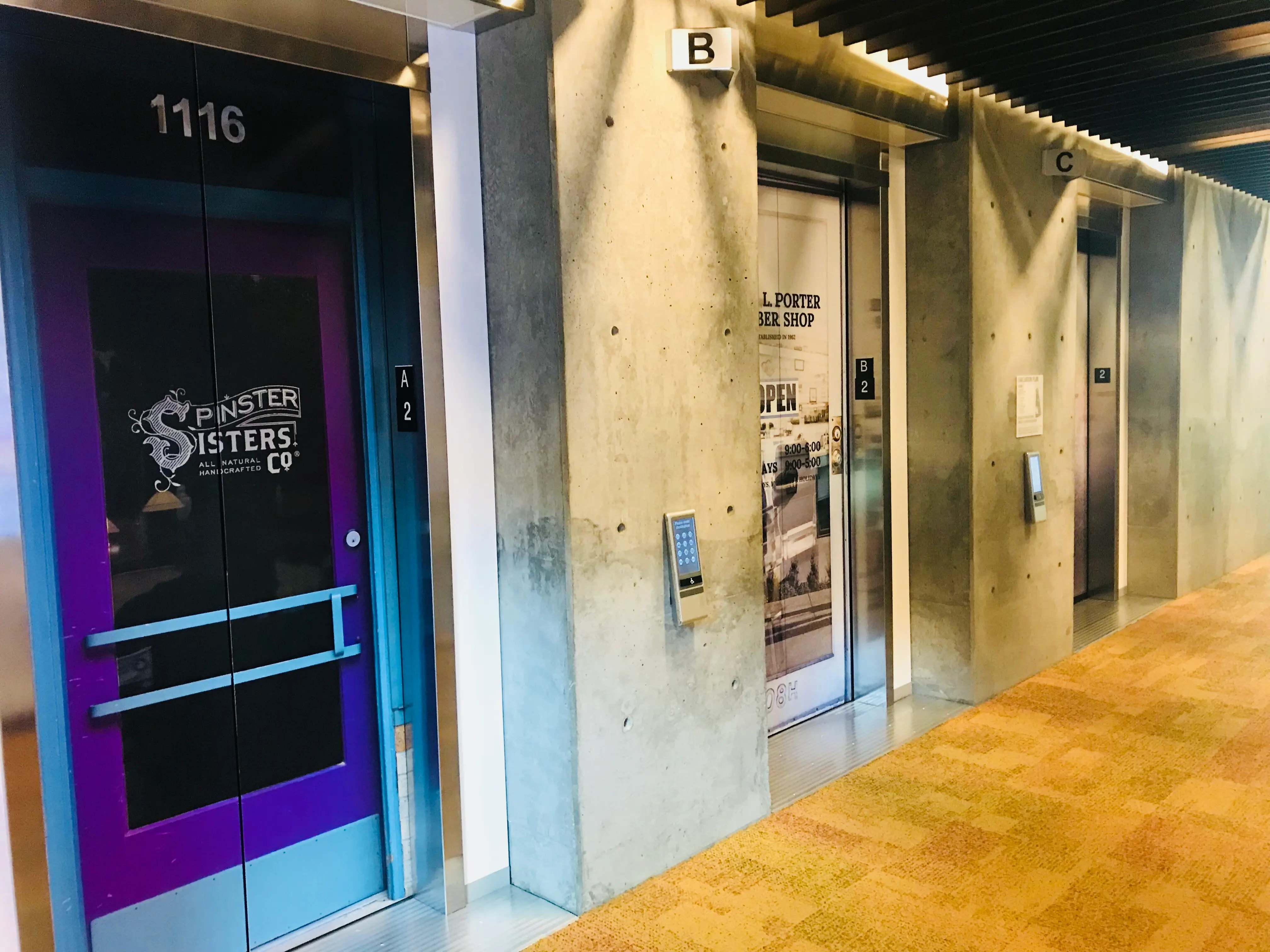 Multi-elevator wrap program at tech company campus Silicon Valley — three elevator bays with distinct full-color vinyl wraps