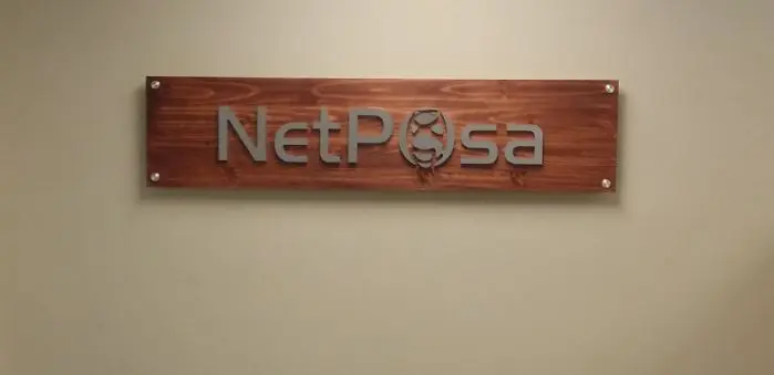NetPosa acrylic lobby sign on wood panel standoff mounted